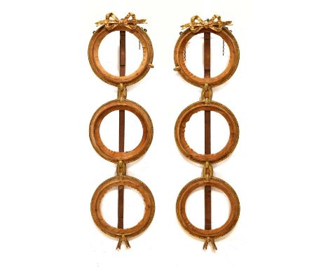 Pair of late 19th century giltwood and gesso triple circular frames, each with ribbon tied crest over three framed roundels e