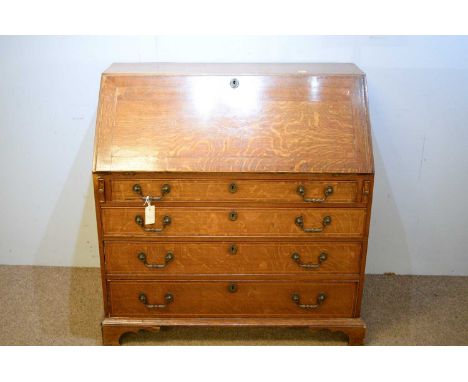 A 19th Century oak bureau, the rectangular top and fall front, enclosing drawers and pigeonholes above four long drawers, rai