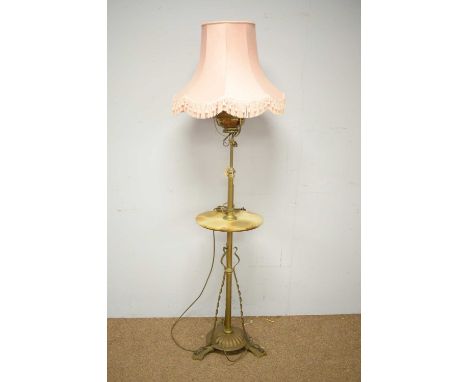 A late Victorian oil standard lamp converted to electricity, with central brass column and oil lamp reservoir, above a green 
