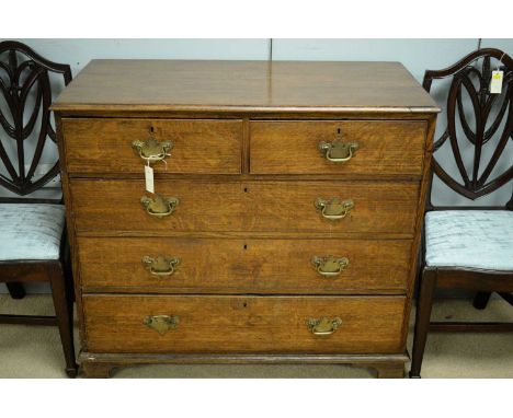 A George III oak chest of drawers, the rectangular top above an arrangement of two short over three long graduated drawers, r