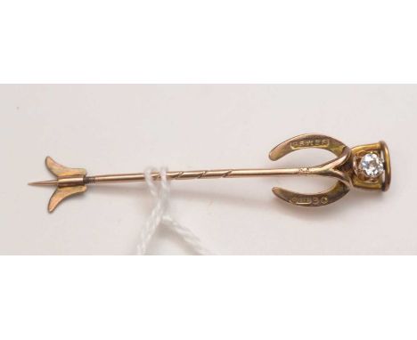 A diamond set tie pin, the 9ct. yellow gold horseshoe pattern tie pin centred by diamond set stirrup, the old cut diamond wei