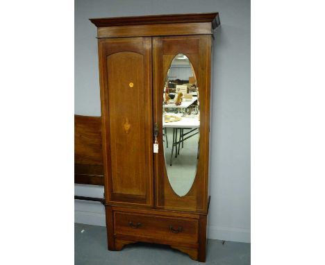 An Edwardian style mahogany two-door wardrobe, the projecting cornice above a single mirrored door enclosing hanging spaces, 