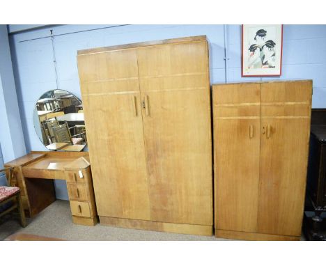 A three-piece Art Deco walnut bedroom suite, comprising: a two-door wardrobe, the caddy top above a pair of burr walnut bande