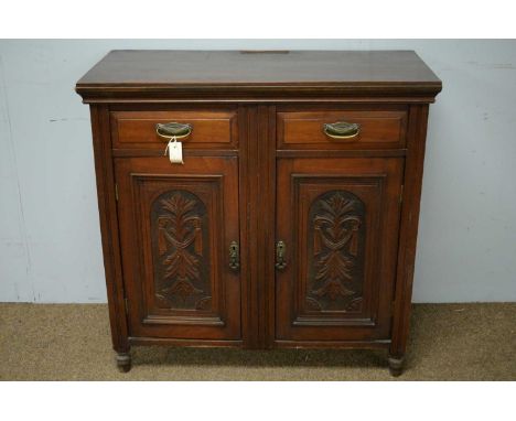 An Edwardian walnut side cabinet, the rectangular top above two frieze drawers and two foliate carved panel doors, raised on 