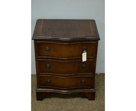 A 20th Century mahogany serpentine fronted bedside chest of drawers, the shaped rectangular top above an arrangement of three