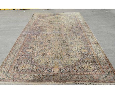 A large machine made Persian style carpet decorated with floral scrolling design 743 x 368cms.