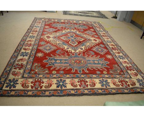 A Turkish Kars carpet, the madder ground with central medallion enclosed by repeating foliate border, 348 x 257cms.