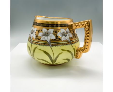 Elegant hand-painted porcelain pitcher featuring a delicate floral motif with white lilies against a soft yellow background. 