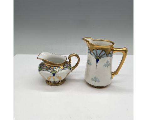 This elegant two-piece porcelain set by Pickard features a pitcher and a creamer, both showcasing exquisite hand-painted flor