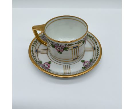 Elegant Pickard porcelain cup and saucer set featuring a hand-painted floral motif with gilded accents. The intricate design 