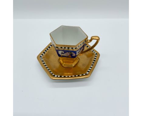 Elegant Pickard porcelain cup and saucer featuring a distinctive hexagonal shape with an opulent gilt finish. The cobalt blue
