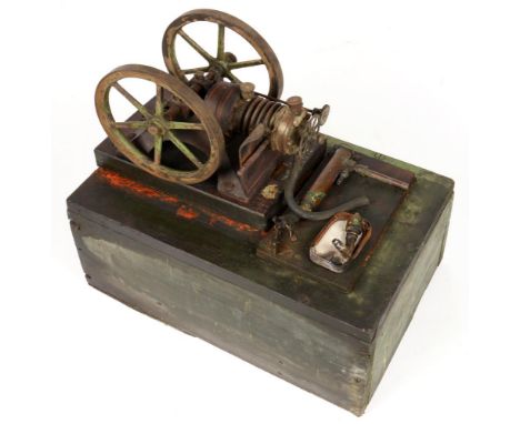 A GEORGES CARETTE MODEL GAS ENGINE, WITH TWO FLYWHEELS, OF CAST IRON AND BRASS, PAINTED BLACK, LINED IN RED AND GREEN, ON OAK
