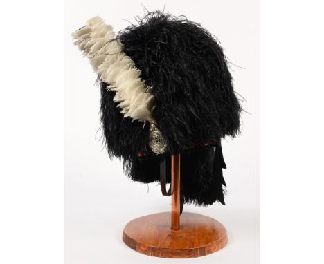 A SCOTTISH FEATHER BONNET AND PLUME ARGYLE AND SUTHERLAND HIGHLANDERS BUSBY HELMET, METAL BADGE ON WOOD STAND 