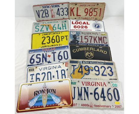 A collection of 12 assorted painted aluminium plates, mostly US automobile plates. 