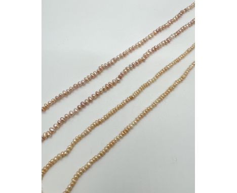 2 freshwater pearl necklaces with spring ring clasps. A 20" pink lustre string of pearls together with a 17" peach lustre str