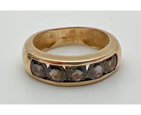 A modern design 9ct gold and channel set Alexandrite half eternity style ring. 5 round cut stones with a total 0.75ct. Full h