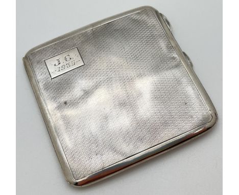 A vintage silver cigarette case with engine turned decoration to front and back. Square cartouche to front with engraved "J.C