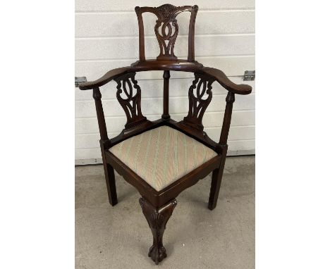 An Edwardian Chippendale style high back corner chair with carved detail. Decoratively shaped support spindles, ball &amp; cl