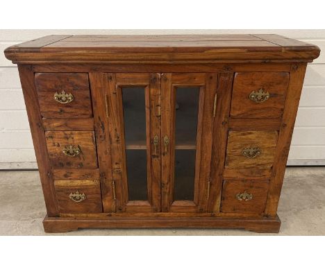 A heavy Indian rubber wood sideboard with 2 central glass panelled doors &amp; 6 small drawers. Central cupboard has interior