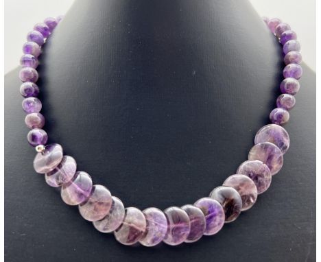 A 15" necklace made from spherical and flat round amethyst beads. With silver tone S shaped hook clasp. Flat bead approx. 1.5