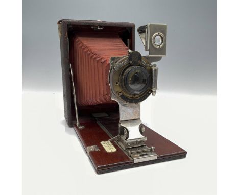 This antique Kodak folding bed camera, crafted by Eastman Kodak, epitomizes the craftsmanship and history of early photograph