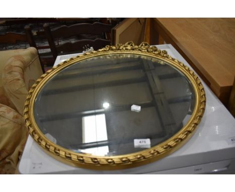 A gilt frame circular wall mirror having foliate bow decoration