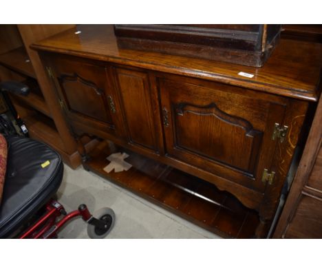 An oak sideboard of small proportions with under shelf