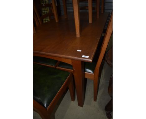 A golden oak dining table with four plus two carver chairs with ladder backs by Peter Hall