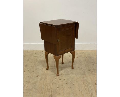 A mahogany veneered side table, the top with drop leaf to each end above a panelled door opening to a shelf, on cabriole supp