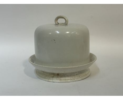 A white ceramic cake stand and domed cover with ring handle to top. (h-28cm w-30) (signs of age and use) (crack to handle a/f