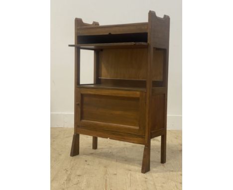 An early 20th century oak reading shelf, with book trough above a writing slide, open shelf and cupboard. H92cm, W58cm, D33cm