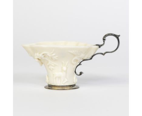 Dehua Chinese white rhinoceros-shaped libation cup decorated in light relief with fantastic animals and leaves in silver (or 