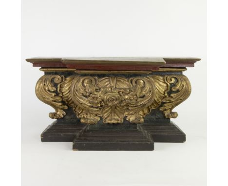 A gilt wooden console in Baroque style, with rich decoration of foliate scrolls, a rosette and flowers in the centre and symm