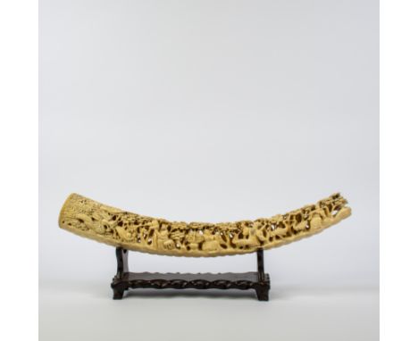 A deep carved elephant tusk depicting a dragon, and immortals in a garden plenty of trees and birds, maker’s stamp on the clo