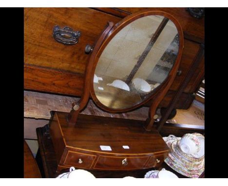 An antique bow fronted toilet mirror with drawers to the front