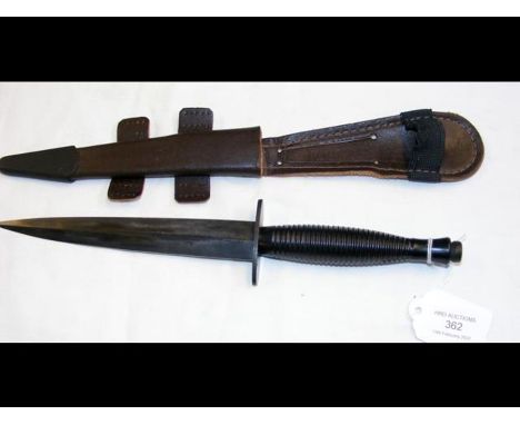 A British commando dagger, Fairbairn Sykes pattern with 17.5cm blackened blade and leather scabbard