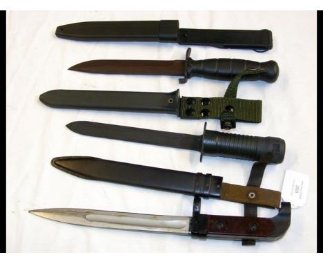 A modern military bayonet with scabbard together with two daggers