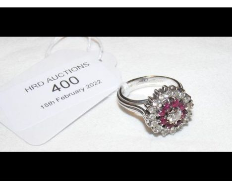 A ruby and diamond cluster ring in 18ct white gold setting - having 17 diamonds and 8 rubies in total