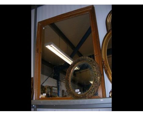 An antique stripped pine wall mirror, together with an oval wall mirror in metal surround 