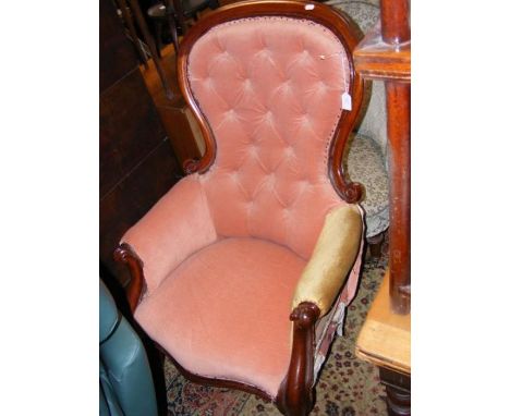 A Victorian easy chair with button back and cabriole front supports 