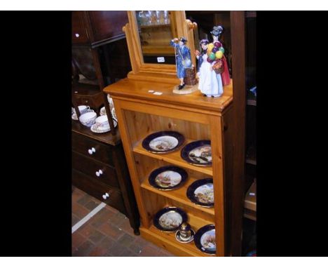 A pine open bookshelf together with a toilet mirror