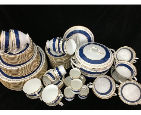 A Coalport Cardova pattern dinner service, decorated with a powder blue band beneath a gilded vine, comprises: two vegetable 