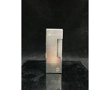 A vintage Alfred Dunhill Rollagas cigarette lighter, silver coloured with gold coloured 'd' inset, engineturned decoration; a