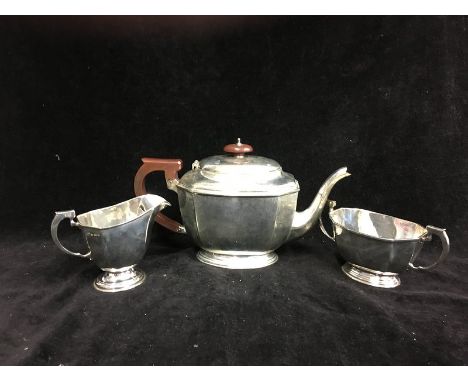 A Mappin &amp; Webb silver three piece Art Deco tea service, of octagonal panelled form, the teapot with wooden handle and kn