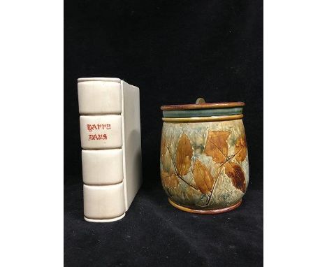 Clarice Cliff - A Happy Days pottery book form flower vase, cream glaze with red script to spine, 18cm high; and a Royal Doul