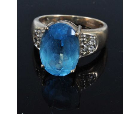 A modern 9ct gold blue topaz and white stone set dress ring, 6g, size M