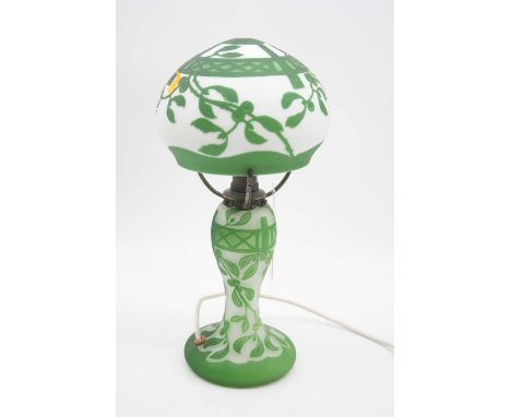 A Gallé style cameo glass table lamp having an opalescent mushroom shaped shade with green floral decoration, the base with f