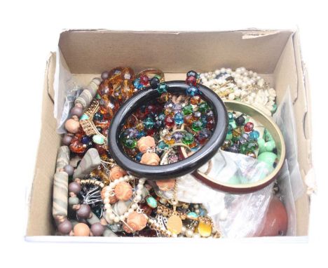 A box of miscellaneous costume jewellery to include modern bangles, plastic and glass beaded necklaces, paste set gents ring,