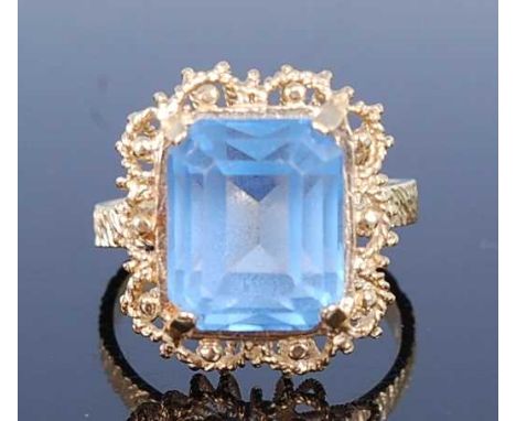A yellow metal paste set ring, comprising a rectangular blue paste stone measuring approx 12.1 x 10.1 x 8.5mm, in a claw set 