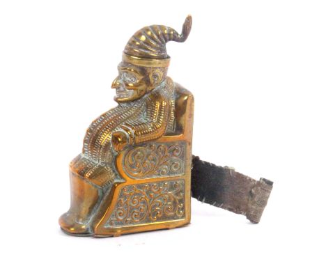 A brass novelty tape measure in the form of Mr Punch seated in a chair, complete printed tape in cms and ins., first half inc